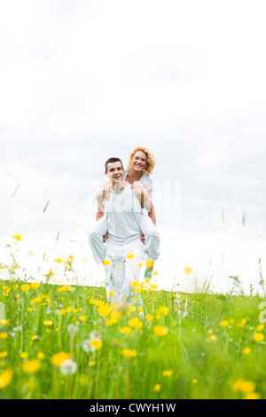 Young man carrying girlfriend piggyback Stock Photo
