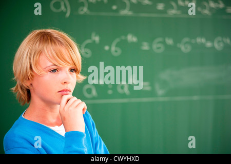 Schoolboy at blackboard thinking about formula Stock Photo
