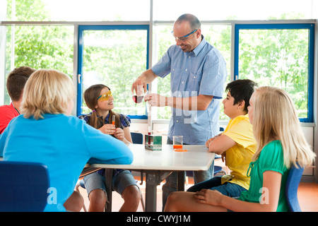 Teacher and pupils experimenting in chemical class Stock Photo