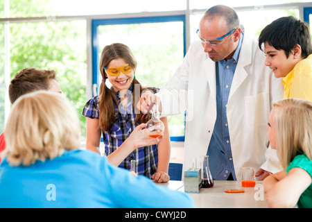 Teacher and pupils experimenting in chemical class Stock Photo
