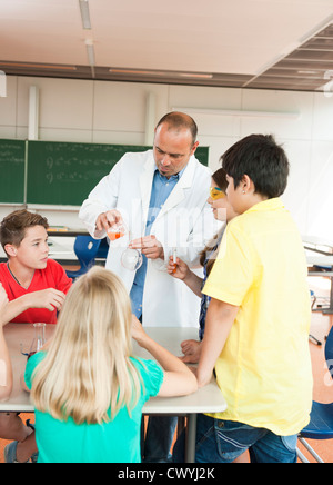 Teacher and pupils experimenting in chemical class Stock Photo