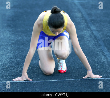 Athletic teenage girl in start position on track . Stock Photo by  ©DenysKuvaiev 11218985
