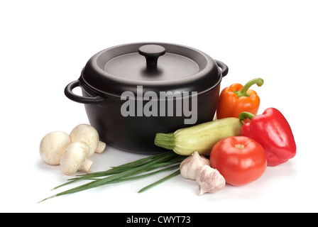 old black cast-iron cauldron with vegetables isolated on white Stock Photo