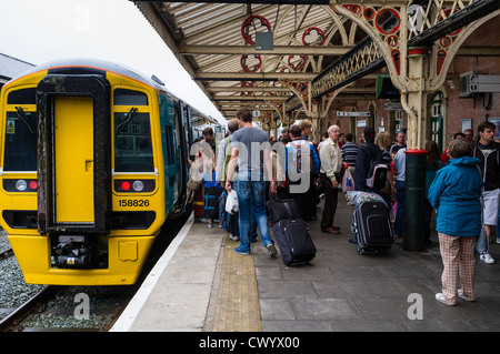 Passengers catching getting on boarding an Arriva Wales train at Aberystwyth railway station, Wales UK Stock Photo