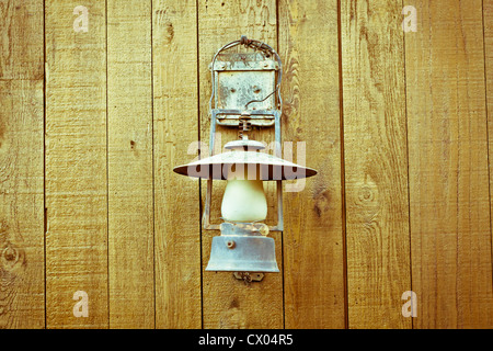 A nice vintage paraffin lamp mounted on a wooden wall Stock Photo