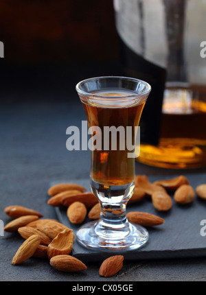 Almond liquor amaretto with whole nuts on a dark background Stock Photo