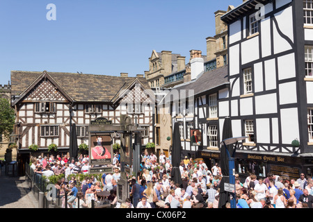 Busy crowd of customers in the beer gardens of the Old Wellington and Sinclairs Oyster Bar, Shambles Square, Manchester. Stock Photo