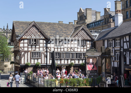 Busy crowd of customers in the beer gardens of the Old Wellington and Sinclairs Oyster Bar, Shambles Square, Manchester. Stock Photo