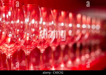 Wine Glasses Lined Up Against a Bright Red Wall Stock Photo