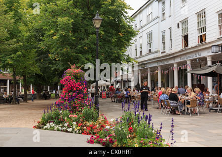 Street scene with flowerbeds and people dining outside Woods restaurant on the Pantiles, Royal Tunbridge Wells, Kent, England, UK Stock Photo