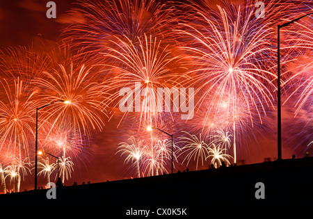 People watch Fourth of July Fireworks from elevated overpass. Stock Photo