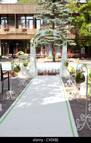 Wedding arch with flowers decoration in tropical resort Stock Photo