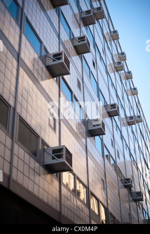 Air conditioners sprout from windows in a building in New York Stock Photo