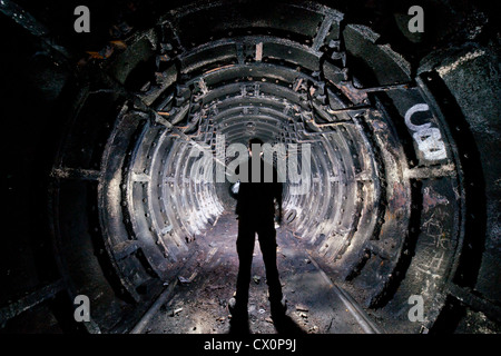 A long tunnel in a Cold War bunker, with a figure in the foreground Stock Photo