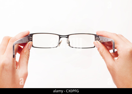 Hands holding eyeglasses on white background. Stock Photo