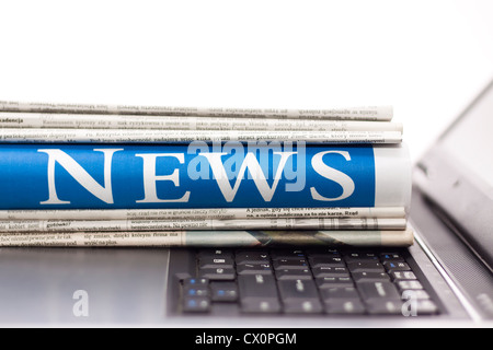 Newspapers on the laptop. Online news. Isolated on white. Stock Photo