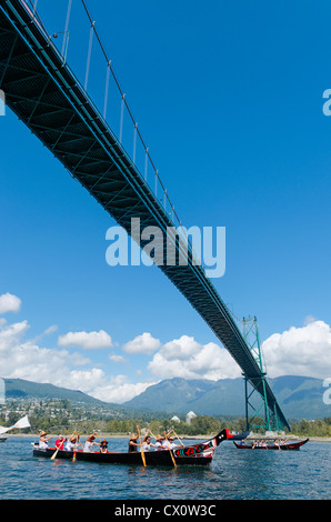 Squamish First Nation paddlers pass under Lions Gate bridge, West Vancouver, BC, Canada Stock Photo
