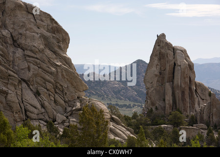 A rock climber is silhouetted at the top of a pinnacle, City of Rocks National Reserve, Almo, ID. Stock Photo