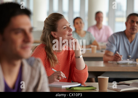 Mature students in class, woman with hand on chin Stock Photo