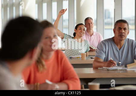Mature students in class, woman with hand up Stock Photo