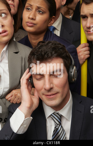 Businesswoman wearing headphones on subway train Stock Photo