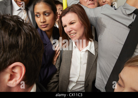 Woman and man with sweaty armpit on crowded subway train Stock Photo