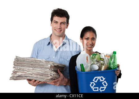 Man and woman holding recycling bin with bottles and newspapers Stock Photo