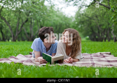 Young couple lying on blanket in park Stock Photo