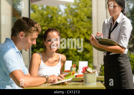 Couple at cafe ordering from menu waitress man point menu Stock Photo