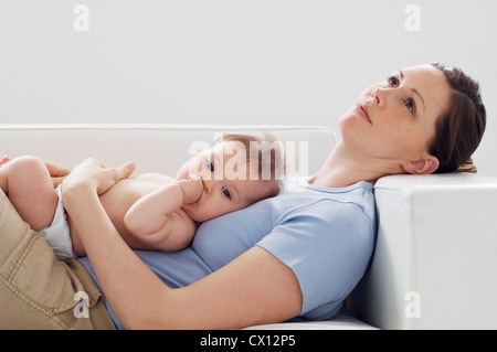 Mother and baby girl on sofa Stock Photo