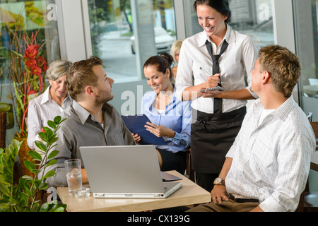 Waitress taking order from businessmen in cafe smiling laptop work Stock Photo