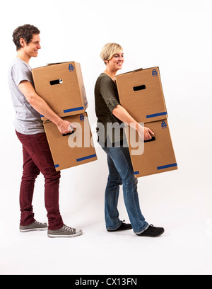 Symbolfoto Umzug, Auszug, umziehen. Junges Paar trägt Umzugskartons. Umzugskisten aus Pappkarton.