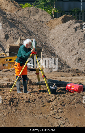 Surveyor and his Leica total station mapping a construction site before the building of a new supermarket in Hørsholm, Denmark. Stock Photo