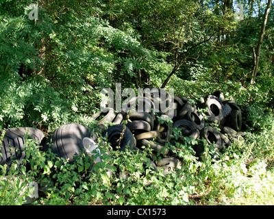 Pile of old tires in woodland, UK Stock Photo