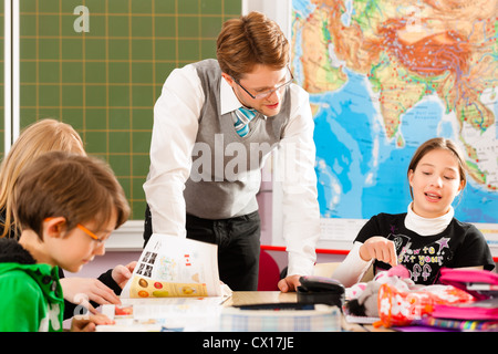 Education - Pupils and teacher learning at elementary or primary school in the classroom Stock Photo
