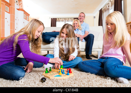 Family playing board game ludo at home on the floor Stock Photo