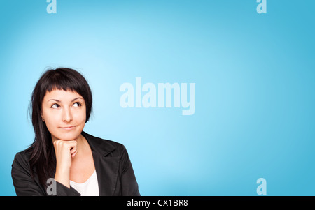 Beautiful young businesswoman think about. Blue background. Stock Photo