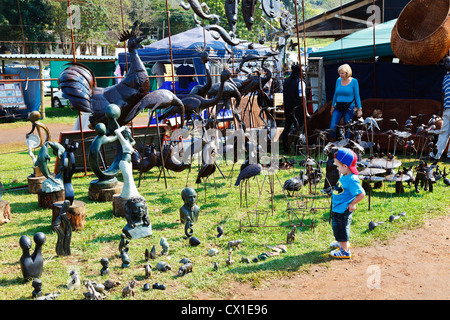 A young boy looks at a display of soapstone carvings and metal sculptures Stock Photo