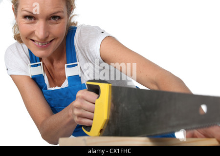 Woman sawing wood Stock Photo
