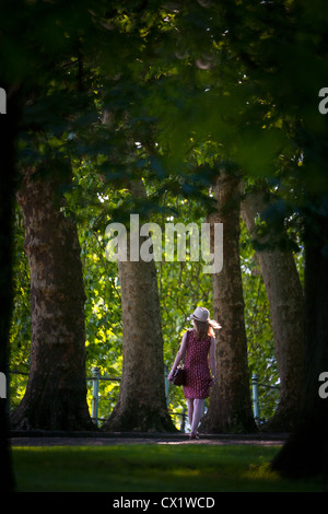 In Summer, a young Lady having a walk in one of the parks of Vichy by a late afternoon (Allier - Auvergne - France). Stock Photo