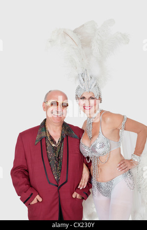Portrait of man with senior showgirl against gray background