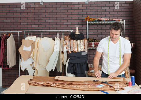 Mature male fashion designer working in design studio Stock Photo
