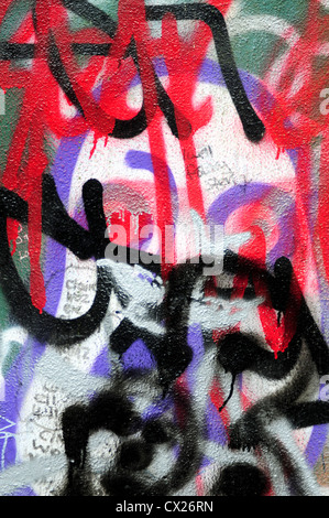 Sprayed graffiti on wall using red, black and purple colours Stock Photo
