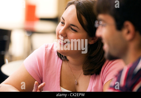 Male and female students smile in a classroom during a college class Stock Photo