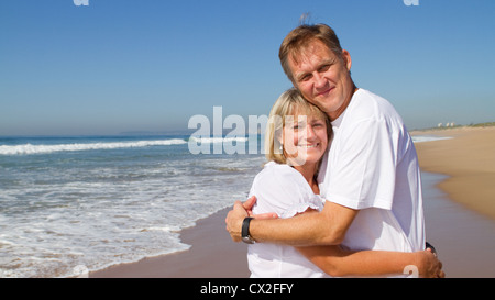 loving middle aged couple hugging on beach Stock Photo