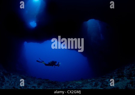 underwater scene of Palau, coral reefs, cave, cavern, diver, silhouette, scuba, diving, blue water, clear water, deep, ocean Stock Photo