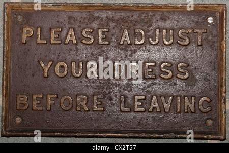 Please adjust your dress before leaving railway sign Stock Photo