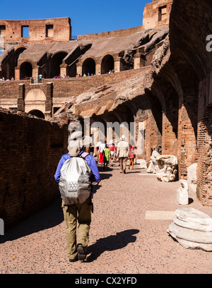 Tourists walking around inside the ancient ruins of the Colosseum, Lazio, Rome, Italy. Stock Photo