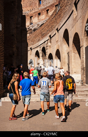 Tourists walking around inside the ancient Roman ruins of the Colosseum, Lazio, Rome, Italy. Stock Photo