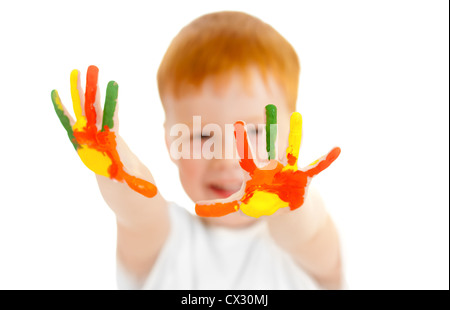 Adorable redheaded boy with focus on hands painted in bright colors Stock Photo